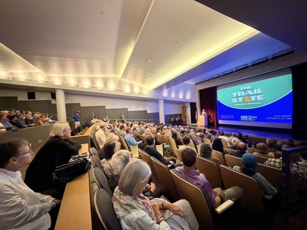A full auditorium at the Missouri History Museum, the title card on the screen