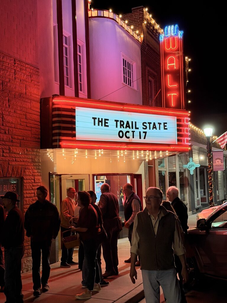 The Walt Theatre marquee lit at night reading The Trail State, Oct 17, with a crowd on the sidewalk